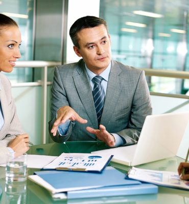 Group of business partners interacting at meeting in office